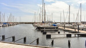 A marina with multiple boats docked, wooden walkways, and a clear sky. - 3 bedroom stunning home in Ystad (Ystad)