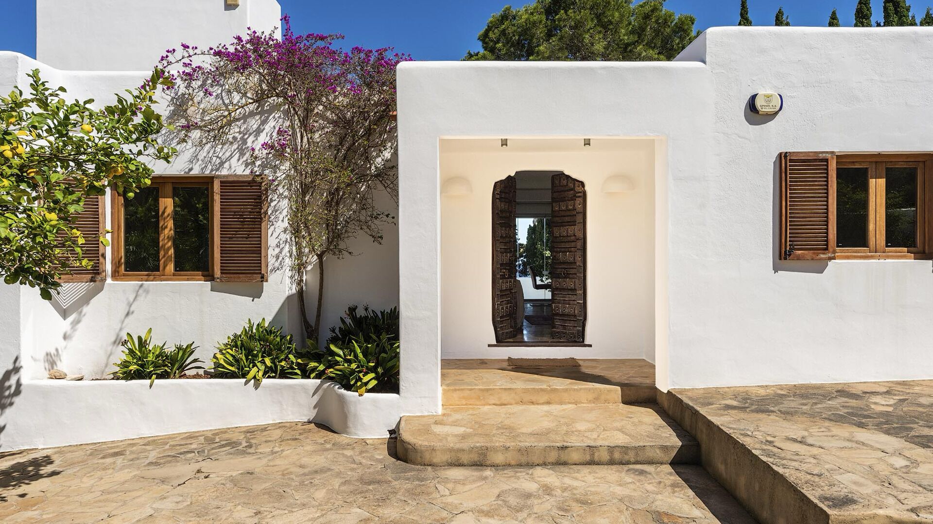 Un edificio blanco con una escalera de piedra que conduce a un arco de entrada.