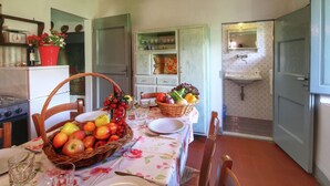 Una cocina con una mesa de comedor para dos personas, un refrigerador y un lavamanos.