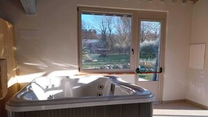 Une salle de bain moderne avec une baignoire sur pieds, de grandes fenêtres et un plafond en bois.