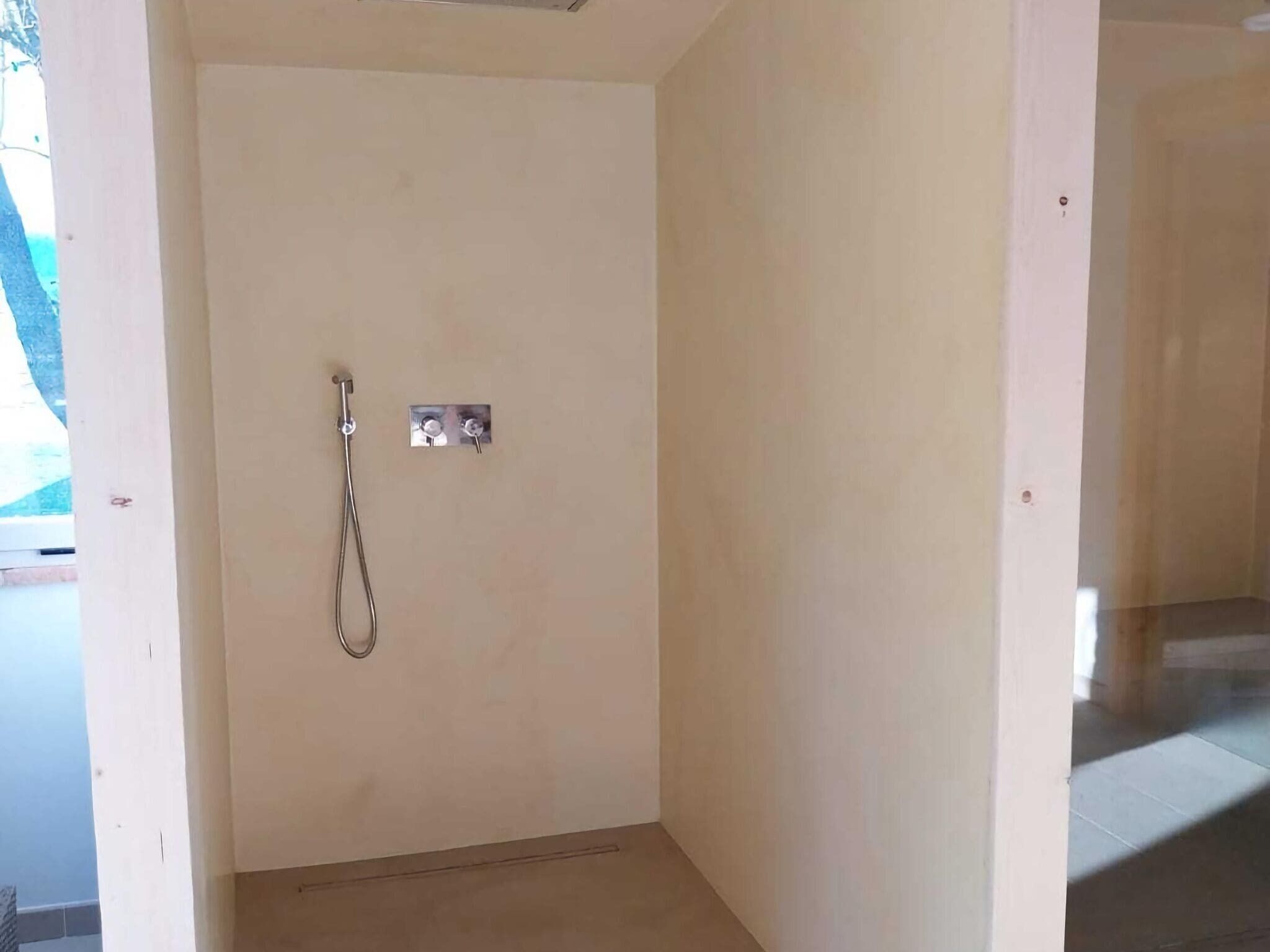 Un baño pequeño y sencillo con ducha, inodoro y lavamanos.