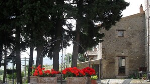 Un edificio de piedra con pared de piedra y macetas con flores.