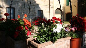 A stone building with a garden in front. - Farmhouse in Umbria near Lake Trasimeno (Gualdo Cattaneo)