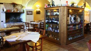 A cozy restaurant with a fireplace, wooden tables, and a bar area with a variety of bottles. - Farmhouse in Umbria near Lake Trasimeno (Gualdo Cattaneo)