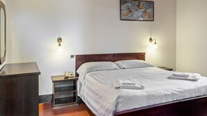 A bedroom with a wooden bed, bedside tables, a telephone, and a painting on the wall. - Cottage in Magione near Lake Trasimeno (Magione)