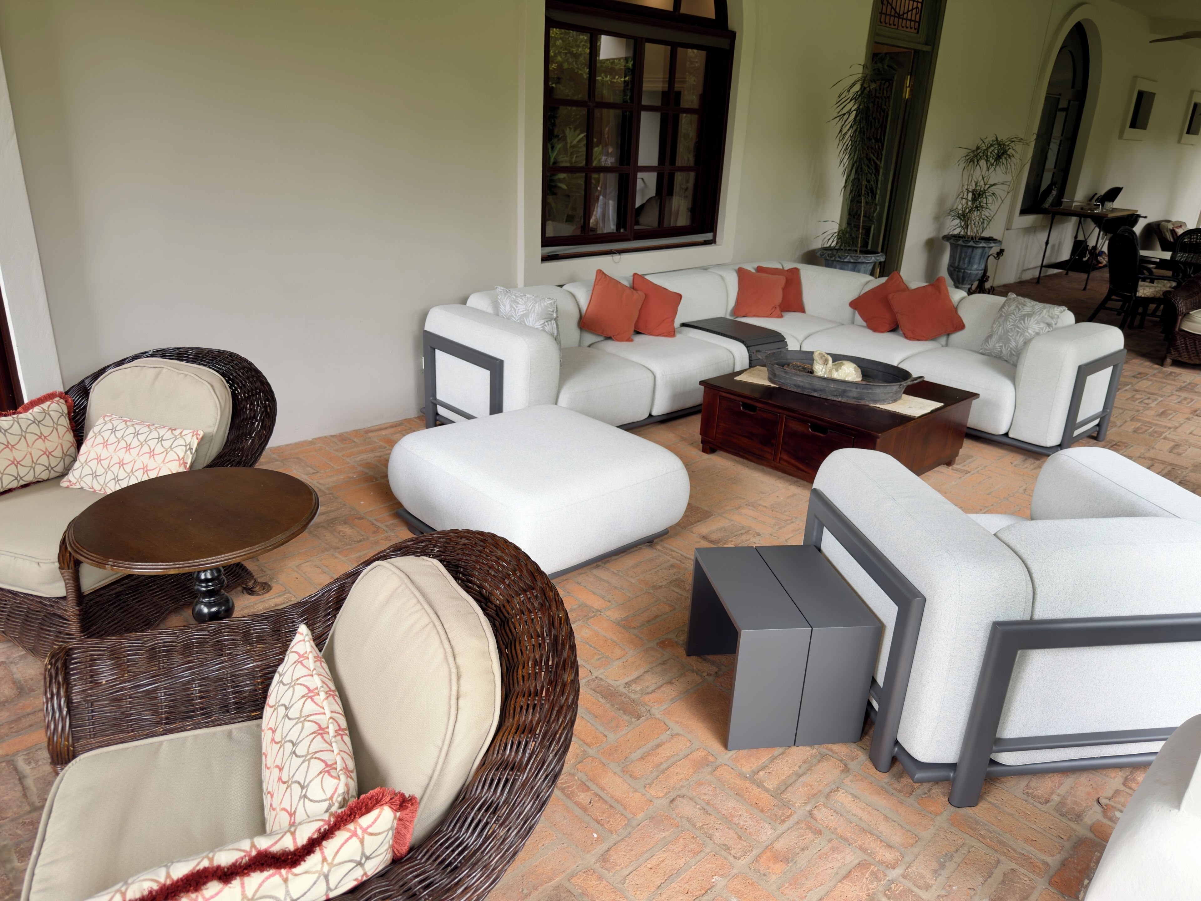 A living room with wicker furniture, a white sofa set, and a coffee table.