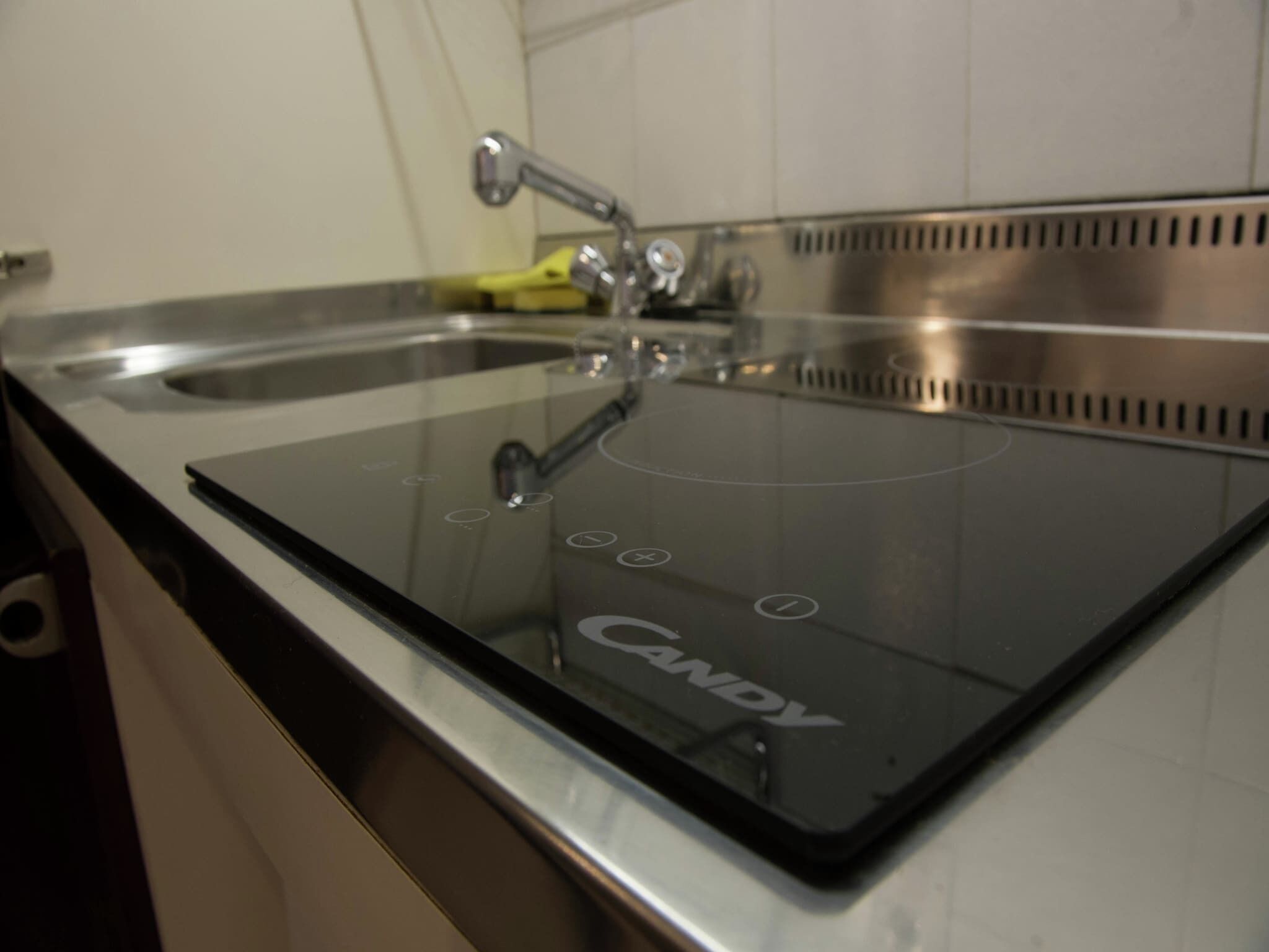 A kitchen with a black countertop and a glass cooktop.
