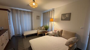 A bedroom with a bed, a desk, a chair, and a lamp.