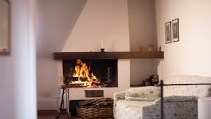 Un salon chaleureux avec une cheminée, un canapé et un plafond en bois.