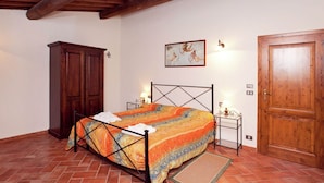 Una camera da letto con un letto, un armadio in legno e una porta.