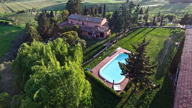 Una villa con piscina rodeada de exuberante vegetación y viñedos.