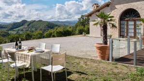 Une terrasse avec une table dressée pour le dîner, offrant une vue sur un paysage montagneux.