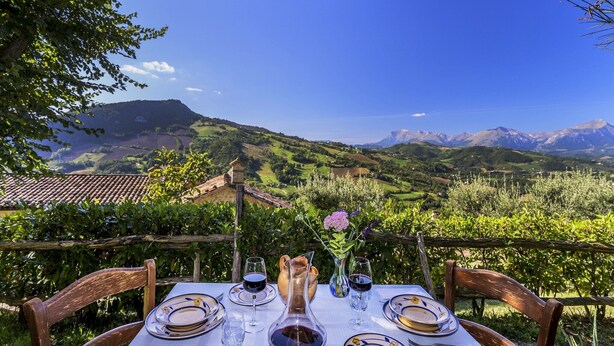 A table set for two with a view of a mountainous landscape. - Relaxing Retreat with bike access (Monte san Martino)