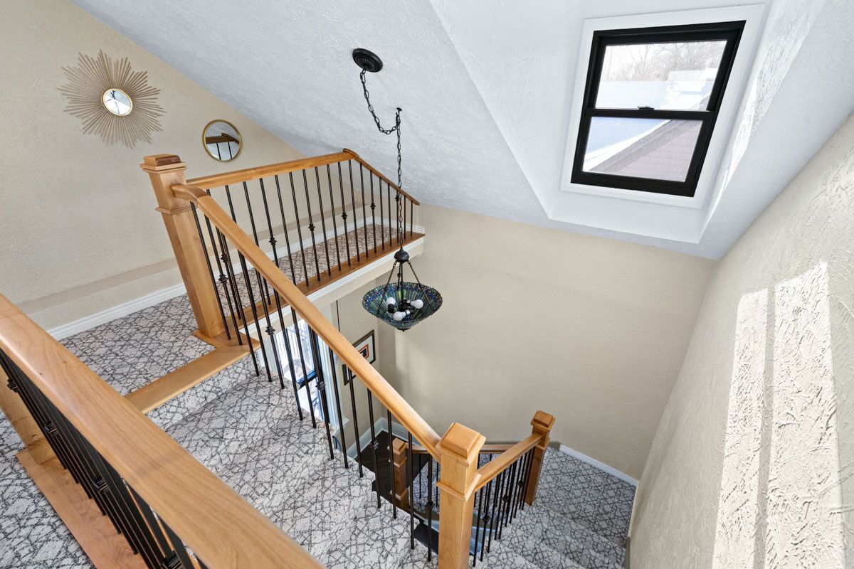 A staircase with wooden railings and a chandelier.