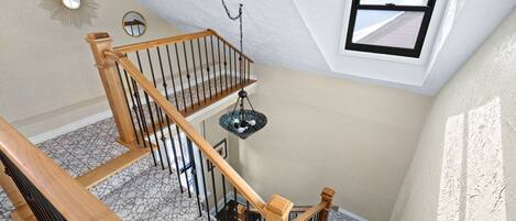 A staircase with wooden railings and a chandelier.