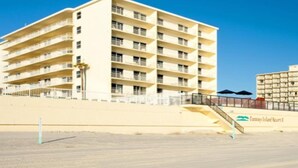 Un hotel de varios pisos con balcones, ubicación frente a la playa y un cartel que dice Fantasy Island Resort.