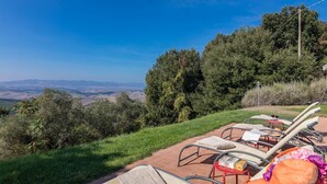 Eine Terrasse mit Liegestühlen und Blick auf die Landschaft.