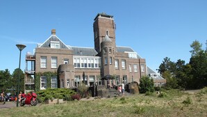Un edificio grande y histórico con una torre destacada y numerosas ventanas.