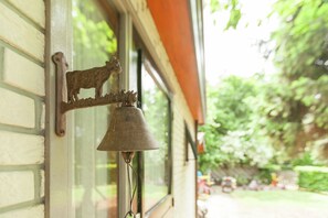 Una campana rústica colocada en una ventana con una figura de animal de metal.