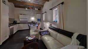 Een gezellig compacte ruimte met een kitchenette, een bank en een eethoek.