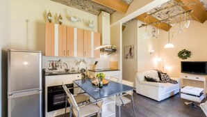 Eine moderne Küche mit Essbereich, ausgestattet mit Kühlschrank, Backofen und Holzschränken.