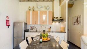 Eine moderne Küche mit Granit Arbeitsplatte, weißen Schränken und einem Essbereich mit Tisch und Stühlen.
