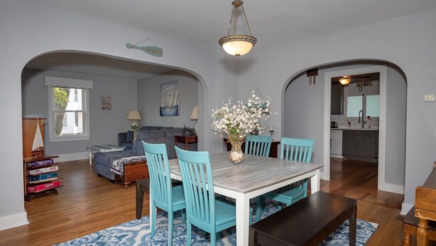 A dining area with a wooden table and chairs, a chandelier, and a vase with flowers. - 2 bdr historic house located one block/walking distance to downtown St. Joe!  (St. Joseph)
