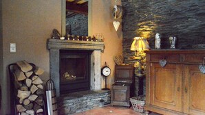 A rustic interior with a stone fireplace, wooden cabinets, and a clock on the wall. - Champlon Villa near Forest (Champlon)