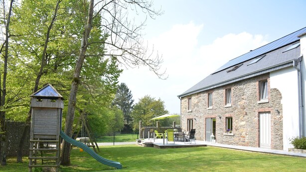 A stone building with a patio area, a slide, and a wooden play structure. - Champlon Villa near Forest (Champlon)