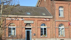Ein Backsteinhaus mit einem Schild, auf dem "CAFE DE LA GARE" und "JUPILER" steht.