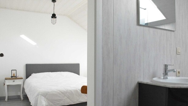 Ein Schlafzimmer mit einem Bett, einem Nachttisch und einem kleinen Tisch mit Stuhl.