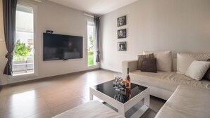 A modern living room with a flat-screen TV, a sofa, and a coffee table.