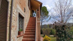 A stone building with a brick staircase leading to a covered porch.