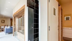 A modern interior with a dining area, a sofa, a kitchen with a sink, and a sliding glass door leading to a balcony. - Peaceful Getaway with Spa, Avelgem (Avelgem)
