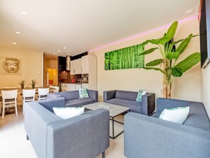A modern living room with grey sofas, a coffee table, and a large green plant. - Peaceful Getaway with Spa, Avelgem (Avelgem)