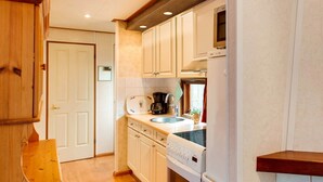 A compact kitchen with white cabinets, a Bosch oven, and a coffee maker.