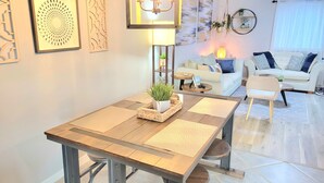 Un salon moderne avec une table à manger, un canapé et des objets de décoration.