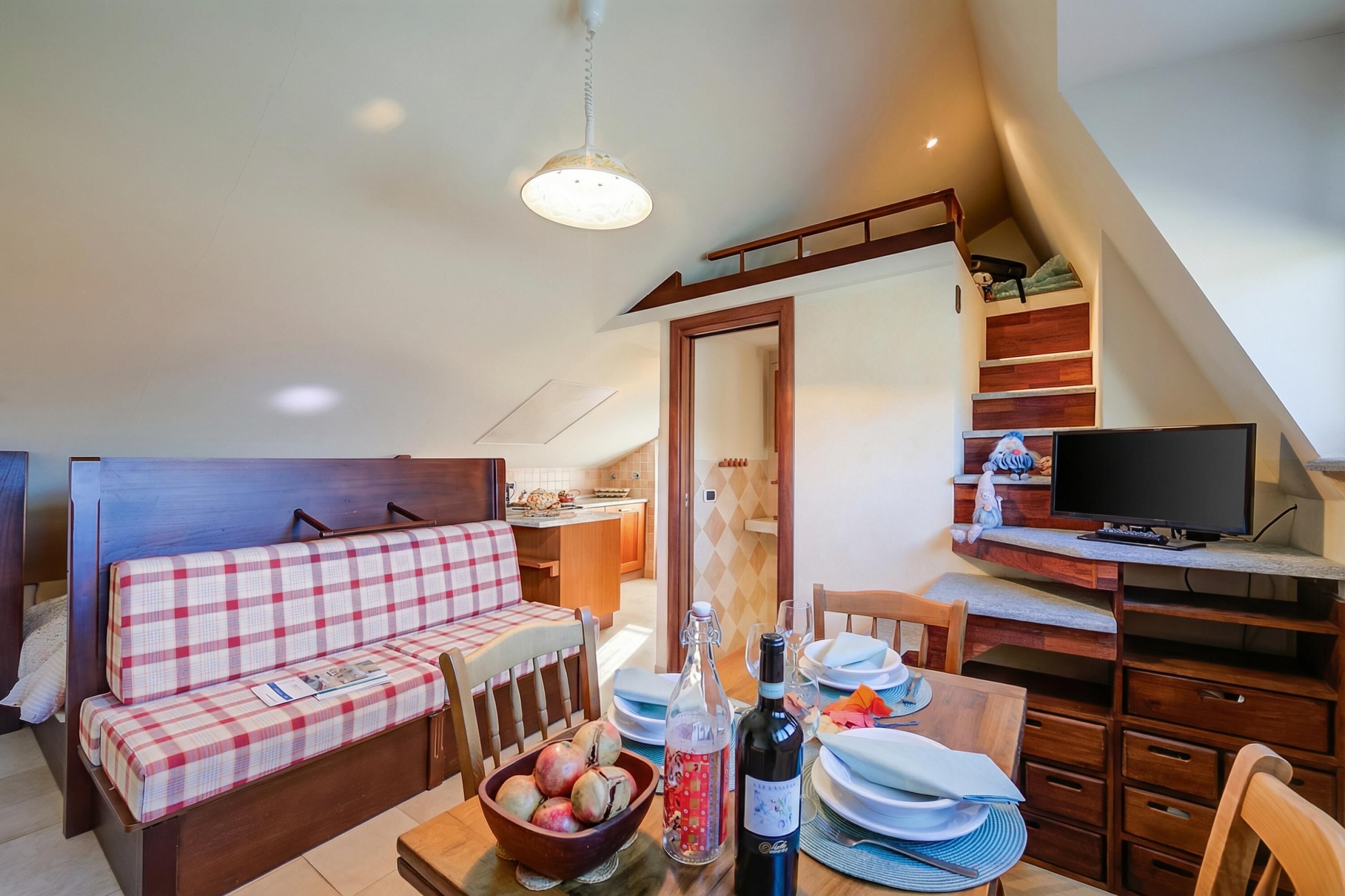 Kodikas oleskelutila, jossa on sohva, ruokapöytä ja televisio.