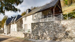 A stone house with a balcony and a stone wall. - Luxury Pool Villa in Sosoye (Sosoye)