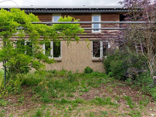 Un bâtiment à deux étages, doté d’une façade en briques, de nombreuses fenêtres et d’une porte bien visible.