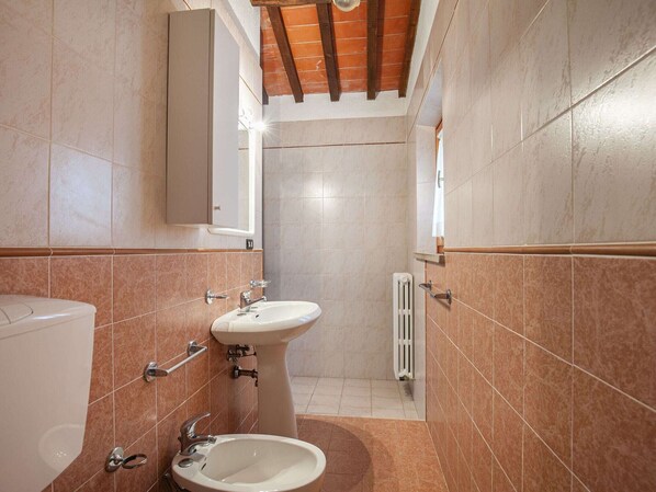 Un baño con lavabo, espejo e inodoro.