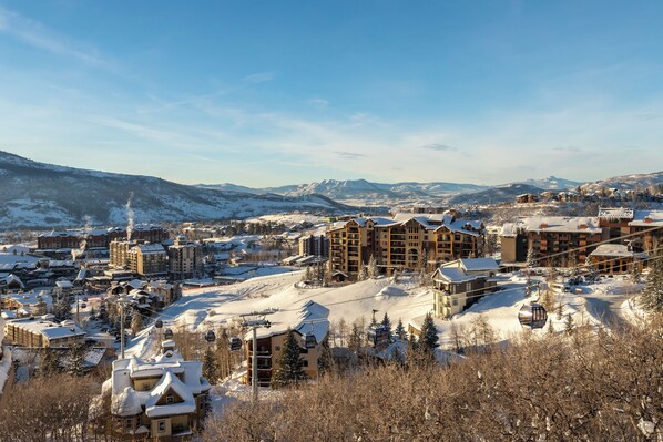 A snow-covered mountain town with multiple buildings, including a large lodge with a ski lift.