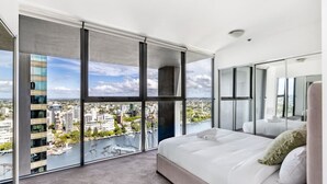 A modern hotel room with a large bed, a view of the city, and a balcony with a cityscape view. - 2BR Apt in the Heart of the City w/ Stunning View (Brisbane City)