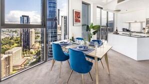 A modern dining area with a city view, a kitchen, and a large window. - 2BR Apt in the Heart of the City w/ Stunning View (Brisbane City)