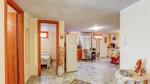 A spacious living area with a dining table, kitchen, and a bedroom with a bed and a wardrobe.