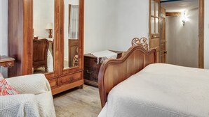 A bedroom with a wooden wardrobe, a bed, and a mirror. - Charming Stay in Viroinval (Viroinval)