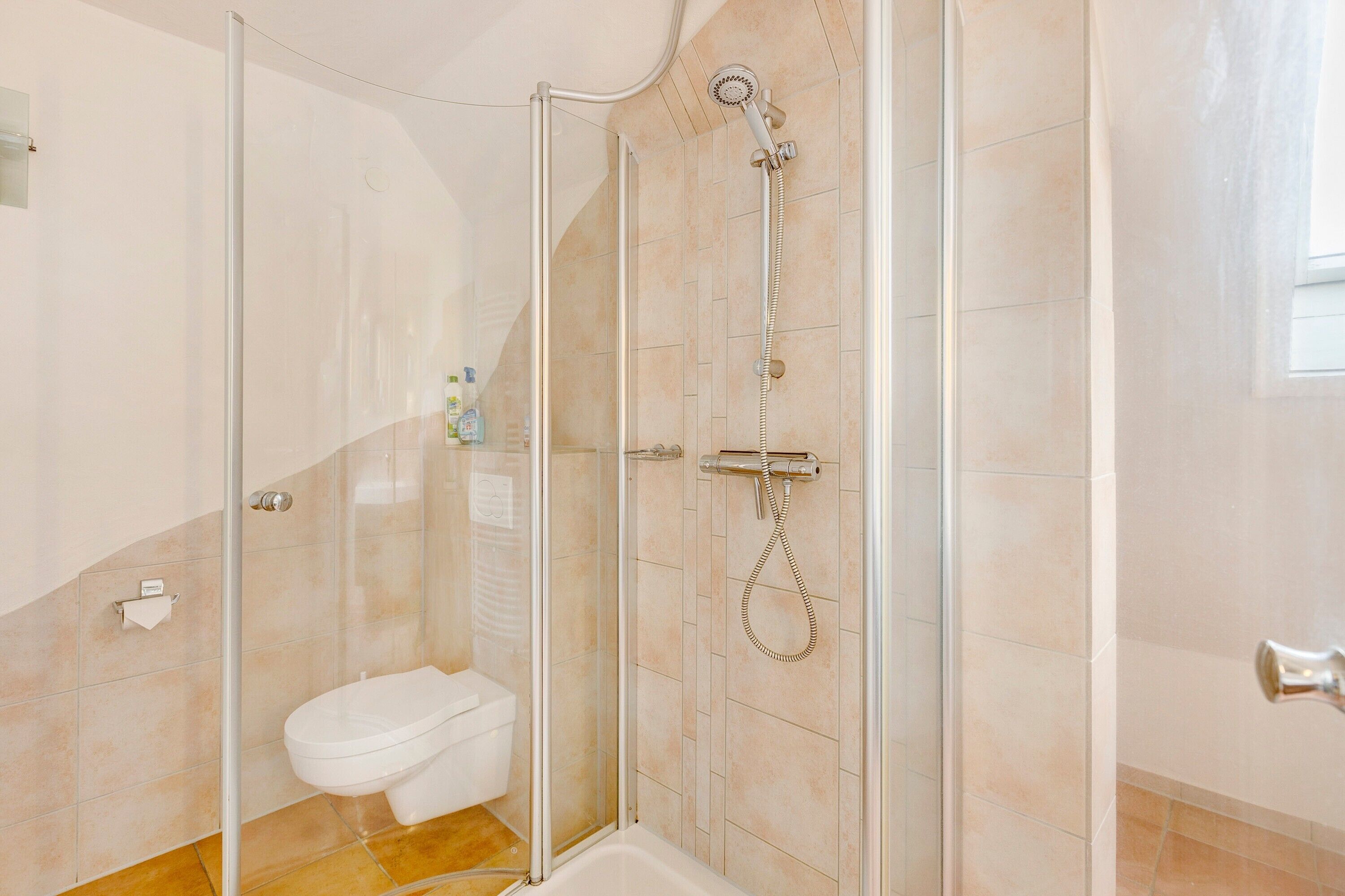 Un bagno con doccia vetrata, un WC e una vasca da bagno.