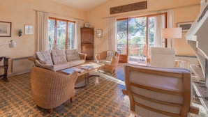 A spacious living room with a sofa, chairs, a coffee table, and a fireplace. Large windows provide natural light and a view of the outdoors. - VILLA MADONNA DELLE GRAZIE (Capoliveri)