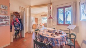A dining area with a table set for two, a music stand, and a view of the outdoors. - VILLA MADONNA DELLE GRAZIE (Capoliveri)