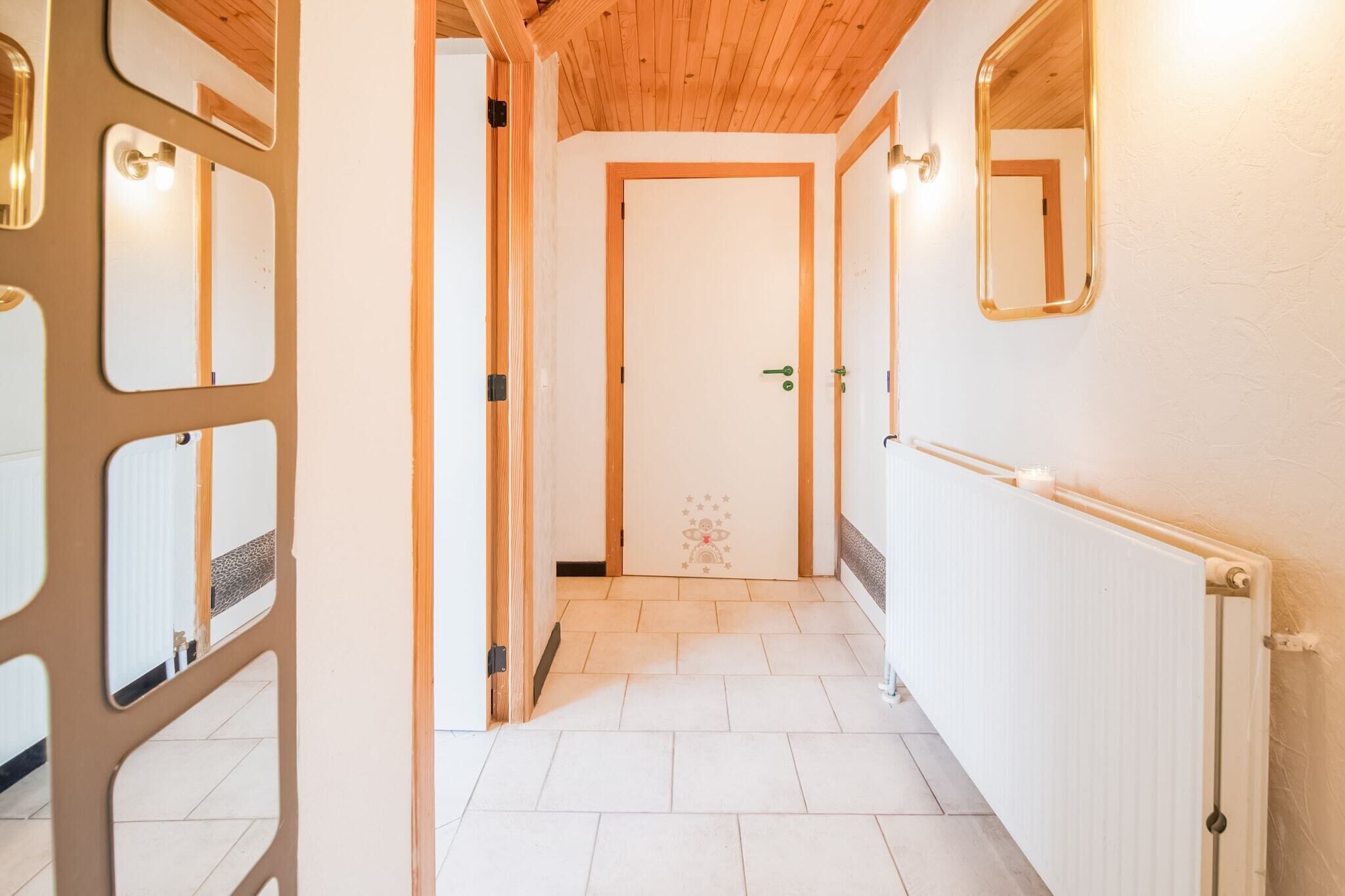 A hallway with a wooden ceiling, white walls, and a radiator.